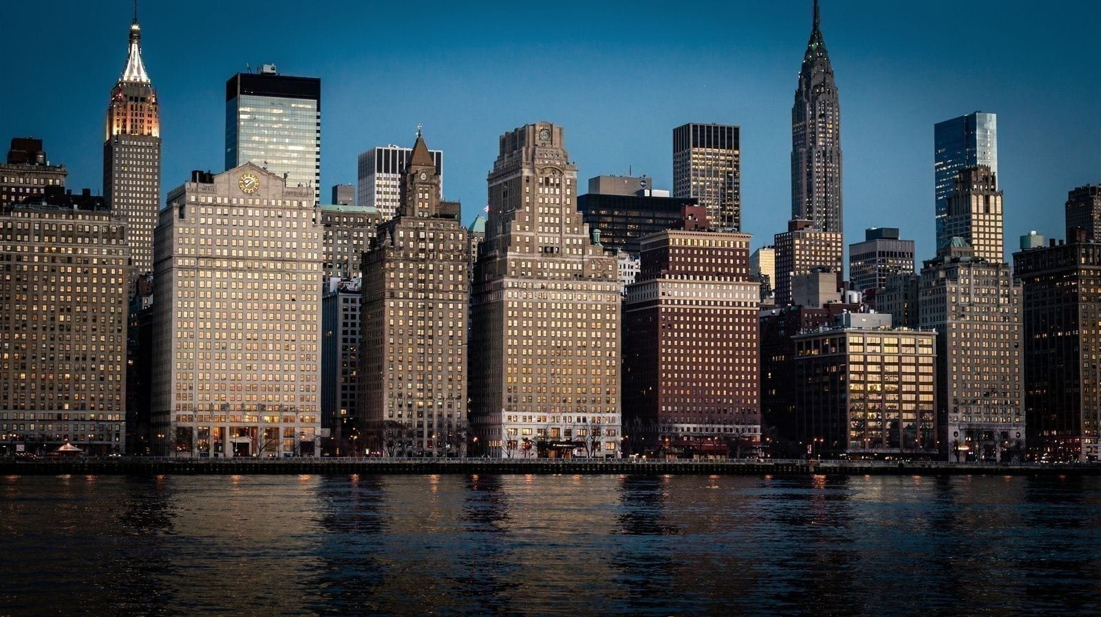 The Manhattan skyline and the Brooklyn Bridge, photographed from the East River waterfront on a clear morning.